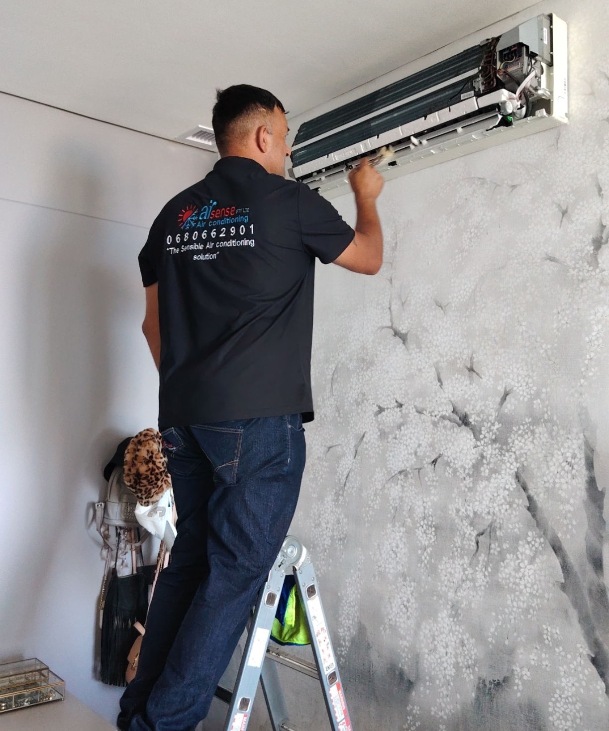 Shaun, owner and lead technician at Airsense Air Conditioning, personally working on an indoor air conditioning unit