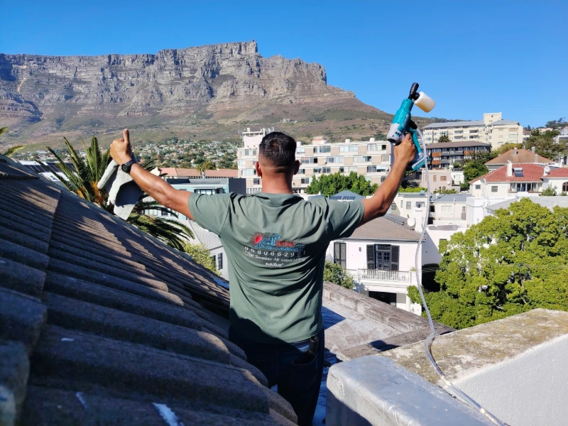 Air conditioning technician on rooftop in Tamboerskloof